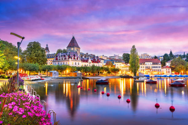 A Swiss lakeside village at sunset, sky and water in pink and gold