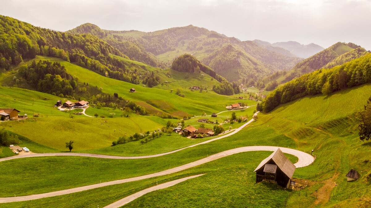 Rolling green Pre-Alps of Gruyère — winding roads, farmhouses and forested hills