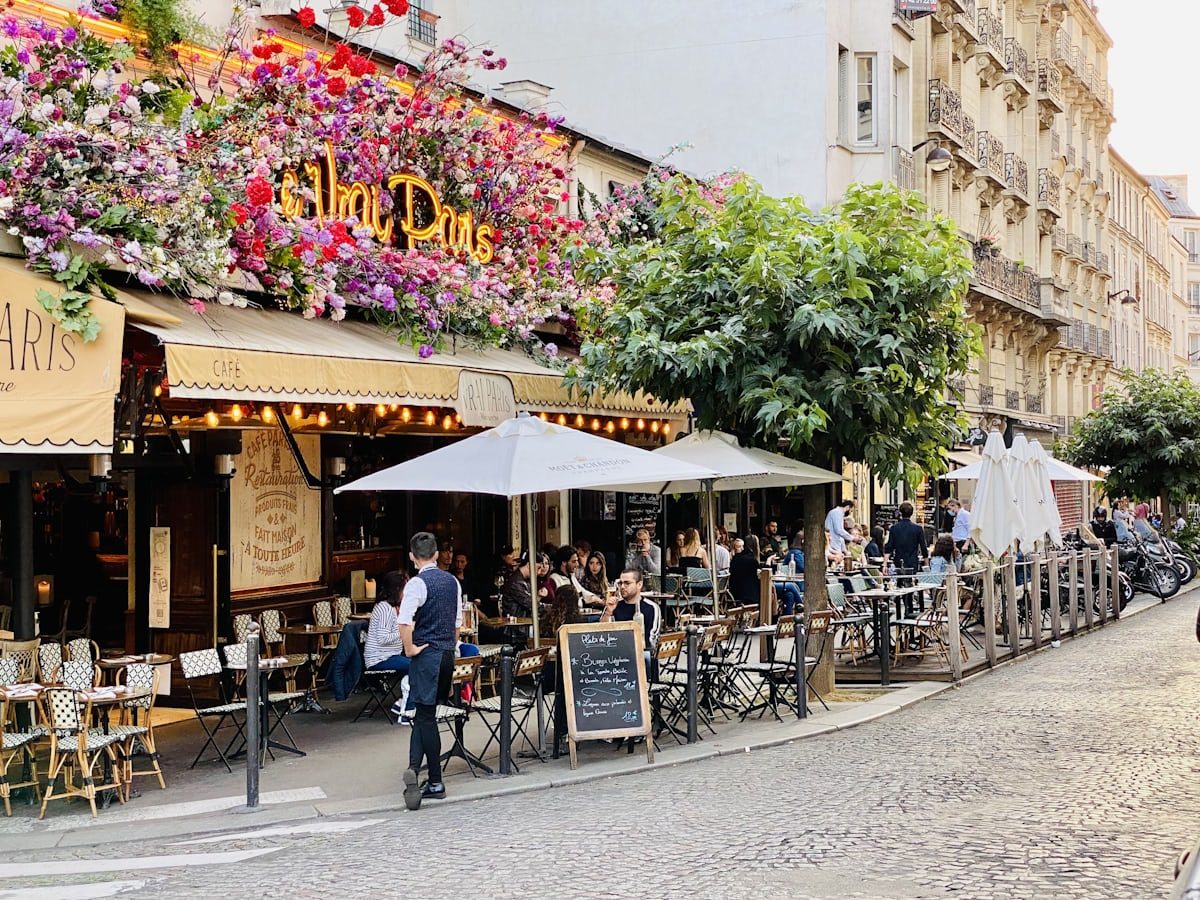 A Parisian café terrace in bloom — flowers, golden light, and the joy of an autumn morning