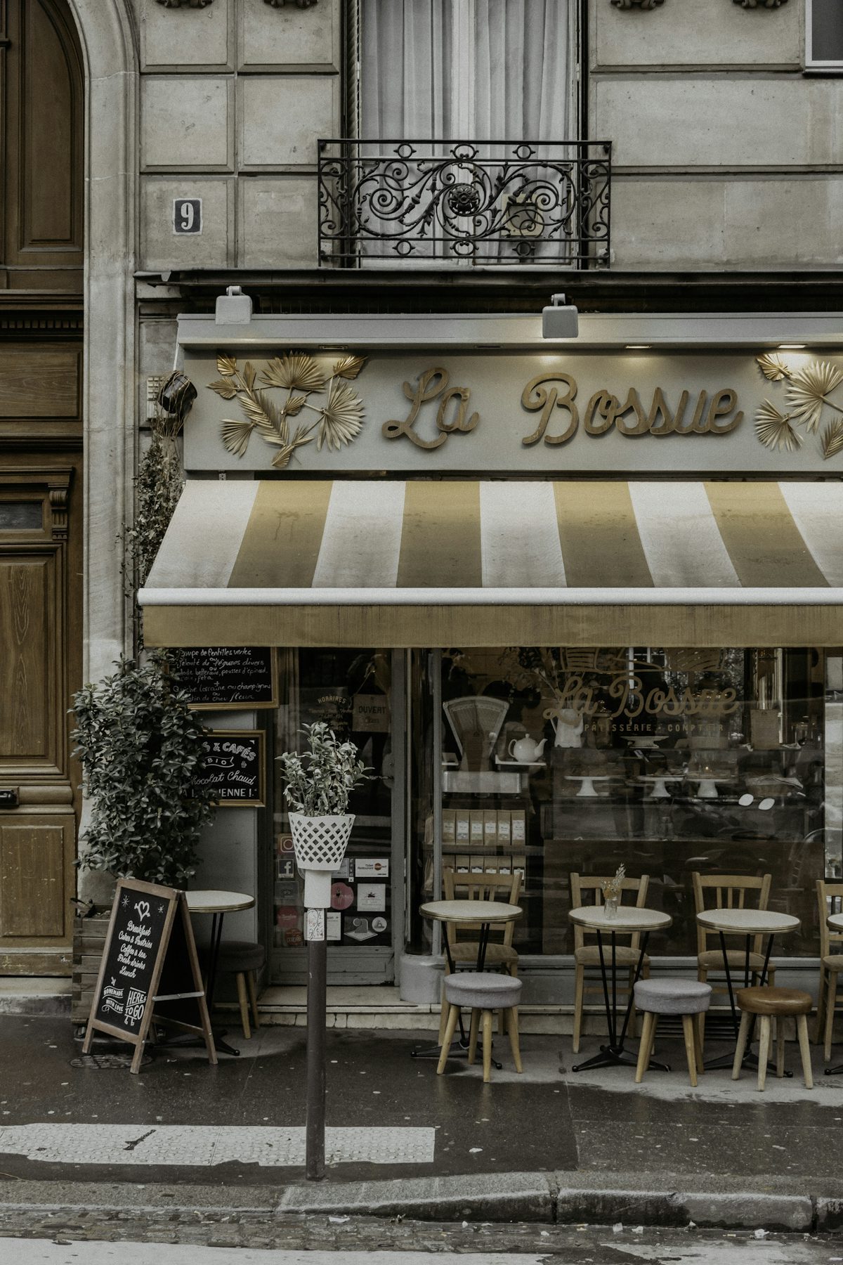 A traditional Parisian café façade with hand-lettered chalkboard menus