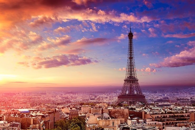The Eiffel Tower silhouetted against a pink-and-violet sunset