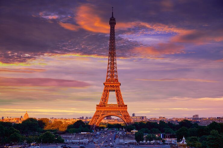 The Eiffel Tower lit against a violet sunset sky