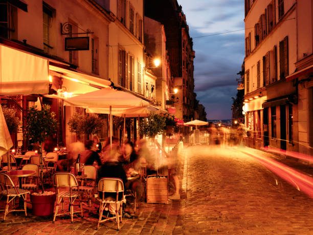 A Paris café terrace alive with people, candlelight, and conversation