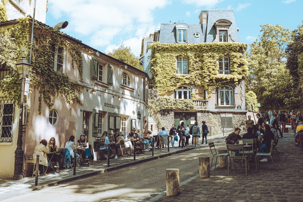 A leafy Parisian café terrace in the soft light of late afternoon