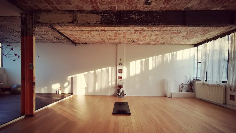 Inside Shala 33 in Montreuil — a sunlit, art-filled practice space with warm wood floors and soft afternoon light